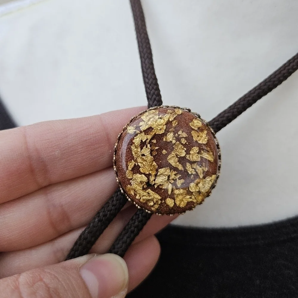 gold leaf and goldstone bolo tie on brown cord